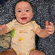 Oakley is registered to the contest to win money with this photo: baby, smiling, infant, blanket, plush_toy, elephant, happy, cute, clothing, onesie, indoor, child, person, face, portrait, skin, head, arms, legs, toddler