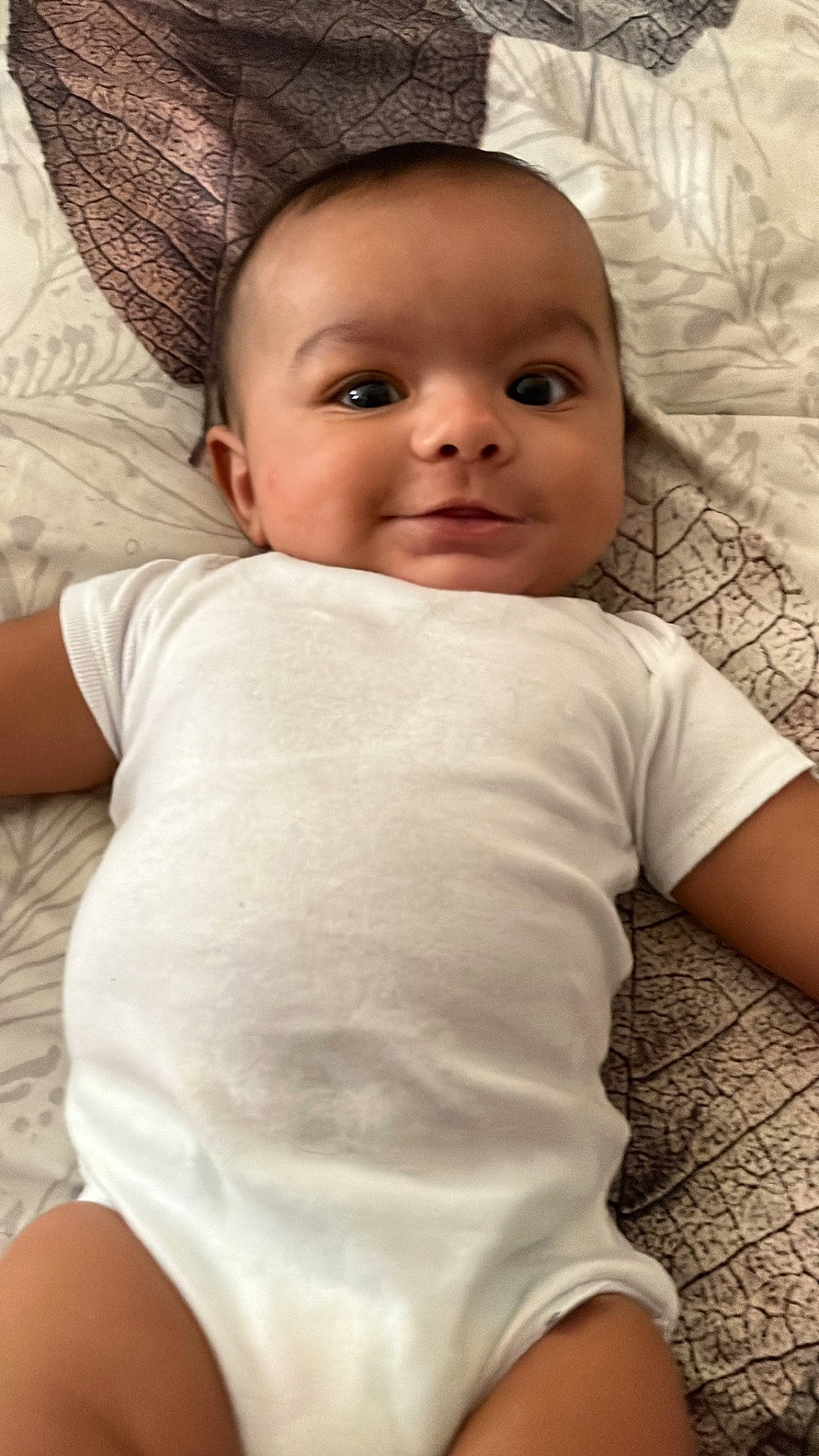 Jace is registered to the contest to win money with this photo: baby, cheek, chin, comfort, elbow, eye, eyebrow, eyelash, face, happy, head, iris, linens, lip, mouth, nose, person, skin, sleeve, smile