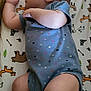baby, sleeping, infant, onesie, blue_clothing, animal_print, crib_sheet, peaceful, cute, newborn, skin, foot, hand, face, ear, leg, lying_down, bed, pattern, child