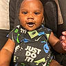 baby, infant, child, portrait, smiling, happy, stroller, seated, black_clothing, nike, patterned_outfit, fashion, close_up, face, eyes, mouth, indoor, casual, adorable, photography