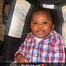 Keyon joined the competition — help win amazing prizes! baby, child, infant, smiling, portrait, car_seat, sitting, plaid_shirt, clothing, bottle, pacifier, indoor, home, floor, flash_photography, close_up, happy, face, hands, text_overlay