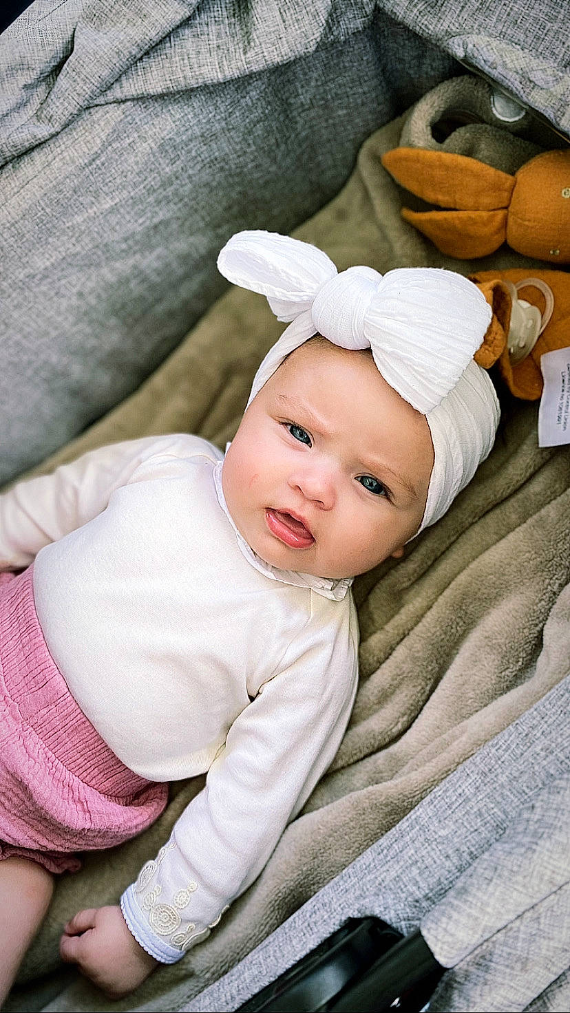 Nell participe au concours pour gagner de l'argent avec cette photo : baby, baby_toddler_clothing, beanie, child, comfort, costume_hat, fashion_accessory, fur, grass, hat, headwear, linens, person, portrait_photography, room, sitting, sleeve, textile, toddler, white