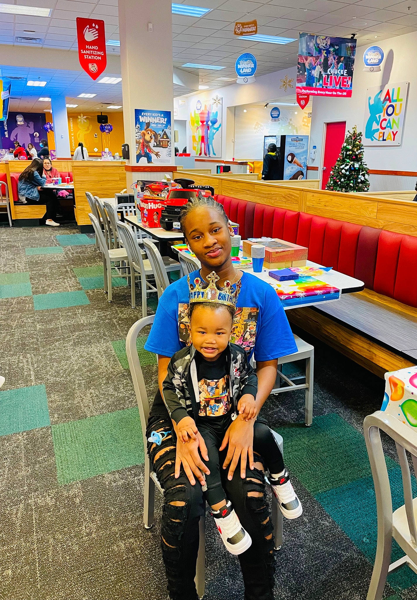 Antonio is registered to the contest to win money with this photo: boot, chair, child, couch, event, flooring, fun, furniture, happy, joy, leisure, person, picture_frame, recreation, recreation_room, room, shelf, smile, t_shirt, table