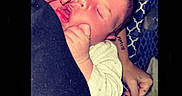 Jeremiah joined the competition — help win amazing prizes! newborn, baby, infant, sleeping, face, eyes_closed, hand, fingers, onesie, blanket, cushion, portrait, indoor, cozy, resting, lying_down, parent, arm, patterned_fabric, photography
