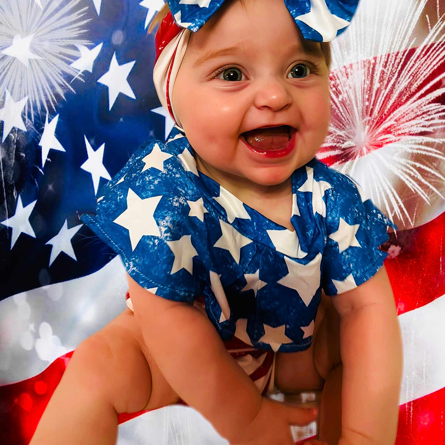 Brinleigh is registered to the contest to win money with this photo: american_flag, baby, background, blue_clothing, bow, celebration, child, cute, face, festive, fireworks, hands, happy, headband, holiday, infant, legs, portrait, smiling, stars