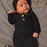 baby, infant, black_outfit, headwrap, blanket, milestone_sign, name_text, portrait, newborn, cute, lying_down, soft_texture, one_month, child, small_hands, button_detail, face, expression, sleepwear, cozy