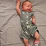 Rosanna joined the competition — help win amazing prizes! baby, infant, sleeping, romper, pink_socks, striped_bed, mattress, newborn, clothing, cute, lying_down, raised_arm, expression, indoor, face, person, child, small, soft_fabric, patterned