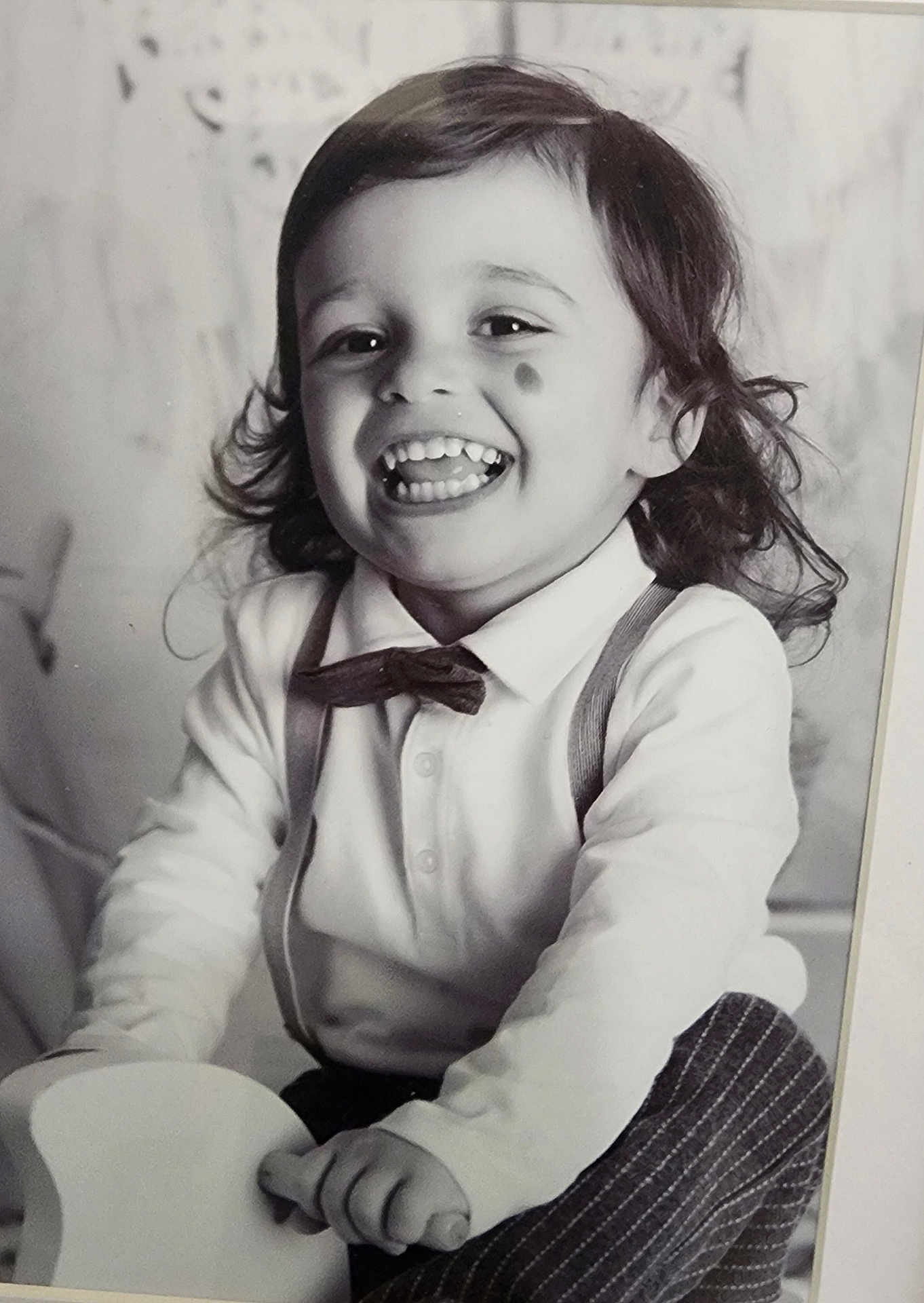 Miguel-Marco participe au concours pour gagner de l'argent avec cette photo : toddler, child, smile, bow_tie, suspenders, toy, black_and_white, portrait, happy, curly_hair, face, clothing, long_sleeve, cute, indoors, playful, person, young_child, joyful, classic