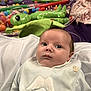baby, infant, bib, angel_wings, toys, green_aliens, balls, purple_blanket, face, person, child, clothing, soft_focus, curious, indoors, cute, portrait, newborn, lying_down, background