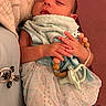 Evelyn joined the competition — help win amazing prizes! newborn, baby, sleeping, infant, portrait, face, hands, blanket, swaddle, clothing, pacifier, teether, beads, crib, indoor, cozy, warm_lighting, caregiver, peaceful, closeup