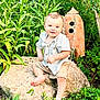 Beau is registered to the contest to win money with this photo: toddler, child, barefoot, rock, grass, plants, greenery, outdoor, nature, garden, shirt, shorts, cute, smiling, portrait, sitting, daylight, young_child, face, curious
