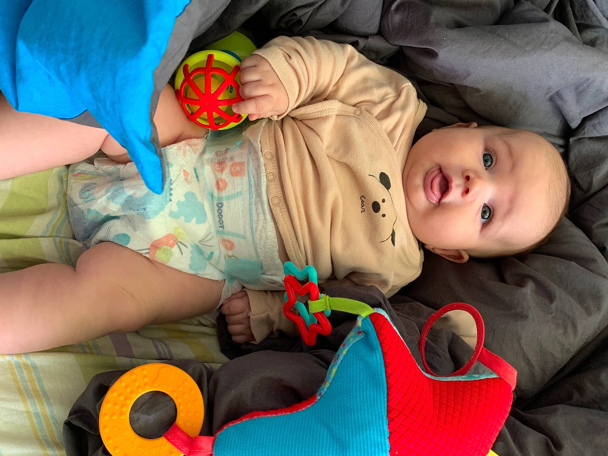 Sevastian a rejoint le concours — aidez-le/la à gagner de superbes lots ! baby, baby_products, baby_toddler_clothing, cheek, child, comfort, fun, green, head, mouth, orange, organ, person, product, red, room, sitting, skin, textile, toddler