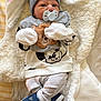 baby, pacifier, beanie, blanket, clothing, footwear, infant, person, cute, soft, warm, sleepwear, toy, animal_print, mittens, laying_down, indoor, newborn, comfort
