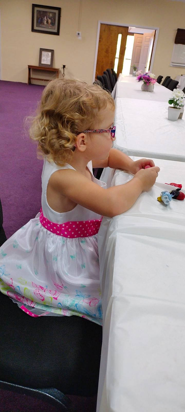 Emmarie is registered to the contest to win money with this photo: baby_toddler_clothing, child, dress, event, eyewear, flowerpot, fun, glasses, happy, houseplant, leisure, magenta, person, pink, plant, play, recreation, room, sitting, table