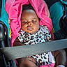 Zoriyah is registered to the contest to win money with this photo: baby, infant, child, car_seat, seat_belt, blanket, pink_blanket, leopard_print, clothing, sitting, portrait, face, eyes, indoors, vehicle, travel, safe, baby_socks, textile, photograph