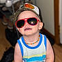 Presley is registered to the contest to win money with this photo: accessories, beaded_necklace, cap, casual, child, colorful_clothing, cute, fashion, happy, headwear, indoor, person, portrait, smiling, standing, sunglasses, tank_top, toddler, wooden_floor, young_child
