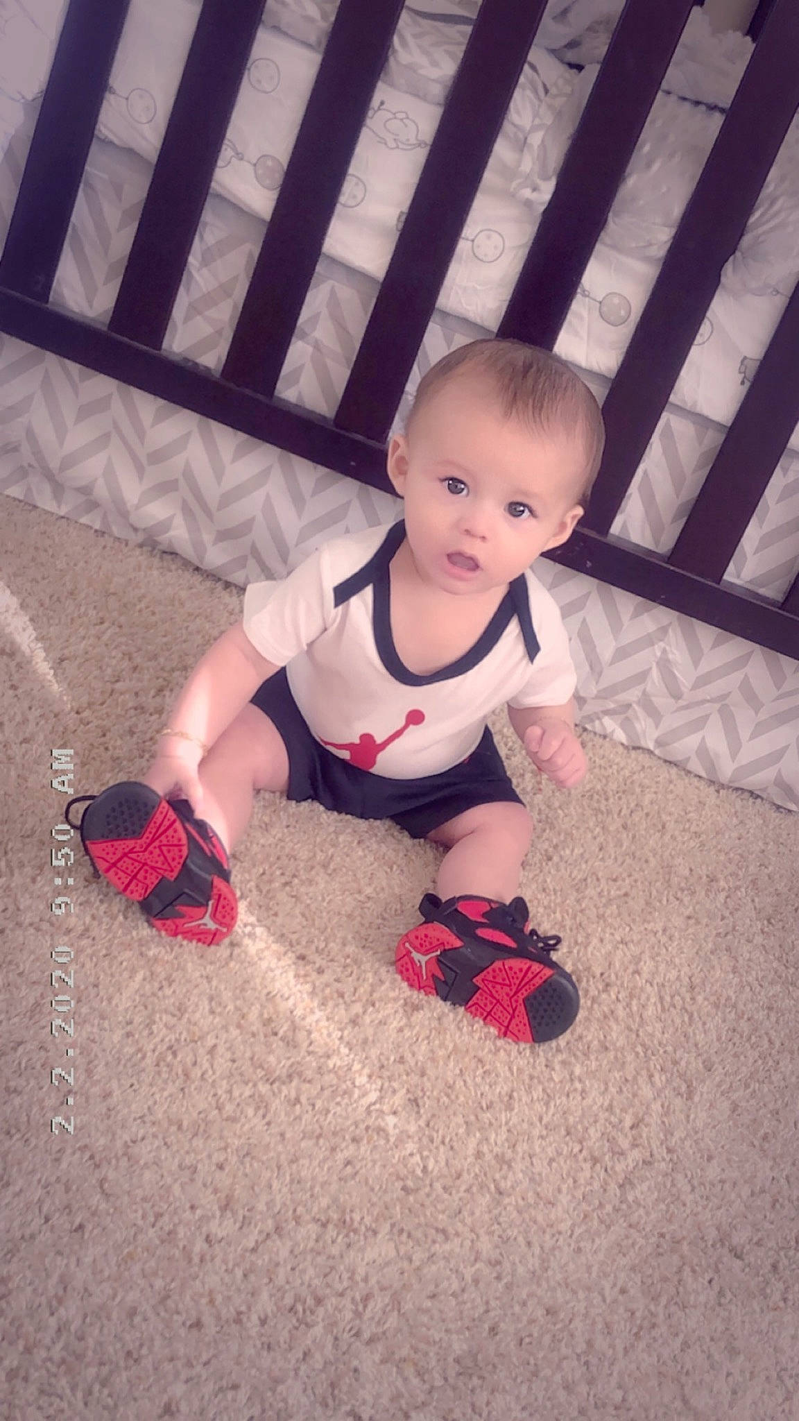 Ismael is registered to the contest to win money with this photo: baby, carpet, cheek, child, electronic_device, flooring, footwear, leg, person, play, red, shoe, sitting, skin, technology, toddler