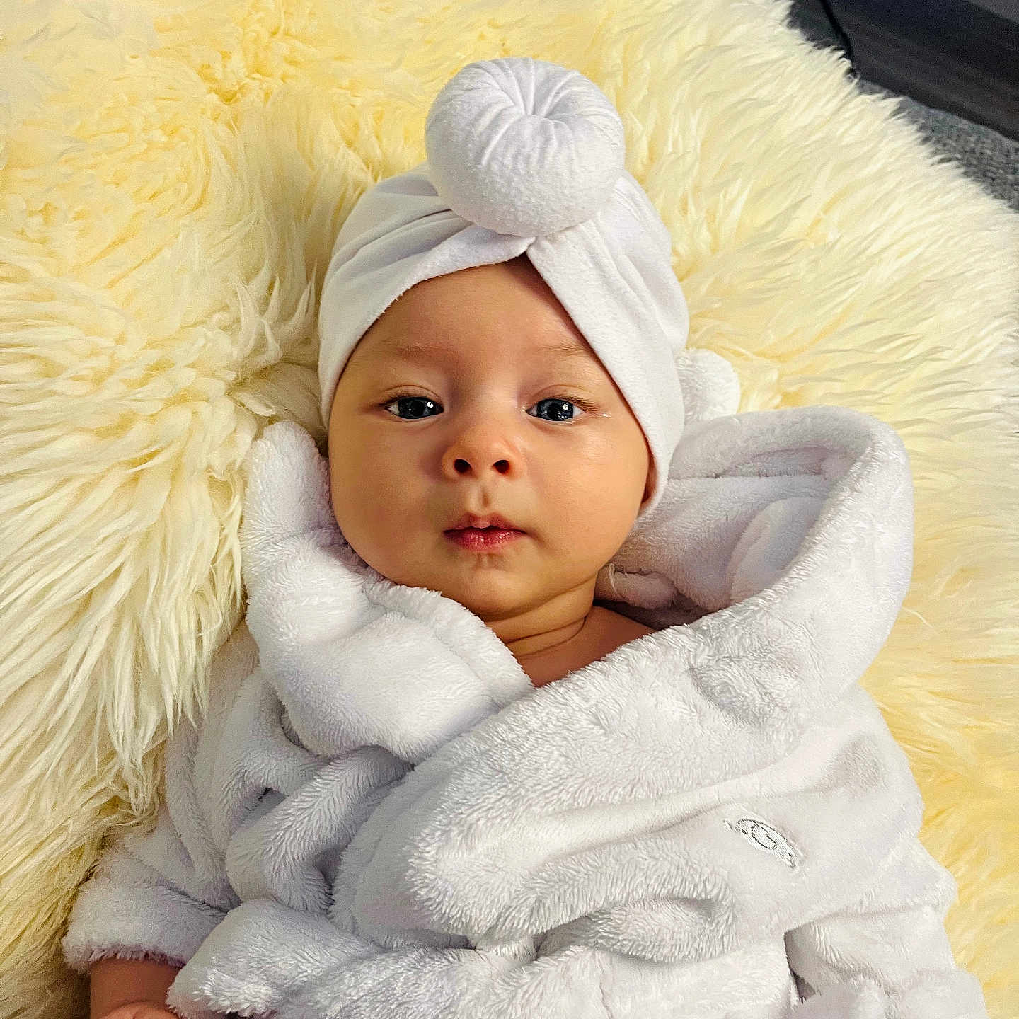 Noah is registered to the contest to win money with this photo: baby, blanket, child, clothing, cozy, cute, eyes, face, fur, hand, headwear, indoor, infant, person, portrait, resting, robe, skin, soft, towel