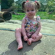 Haisley is registered to the contest to win money with this photo: toddler, child, pigtails, romper, outdoor, grass, concrete, face, smile, dirt, sunlight, trees, nature, baby, sitting, cute, playful, skin, daytime, casual