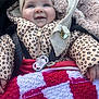 baby, blanket, child, clothing, cute, face, hand, happy, headband, infant, jacket, knitted, leopard_print, outdoor, pacifier, red, smiling, stroller, warm, white