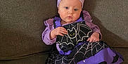Haven joined the competition — help win amazing prizes! baby, child, purple_clothing, headband, bow, bat, spider_web, couch, indoor, cute, infant, sitting, portrait, costume, holiday, halloween, foot, person, smile, young_child