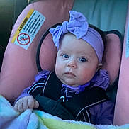 Haven joined the competition — help win amazing prizes! baby, child, car_seat, blanket, purple_headband, blue_eyes, infant, person, portrait, clothing, seat_belt, indoor, cute, face, headwear, sitting, young_child, soft_fabric, car_interior, baby_girl