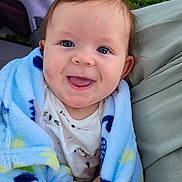 Camden is registered to the contest to win money with this photo: baby, child, smiling, blanket, blue_blanket, stroller, happy, face, cute, infant, clothing, outdoor, nature, person, portrait, small_hand, soft_texture, head, cheerful, eyes