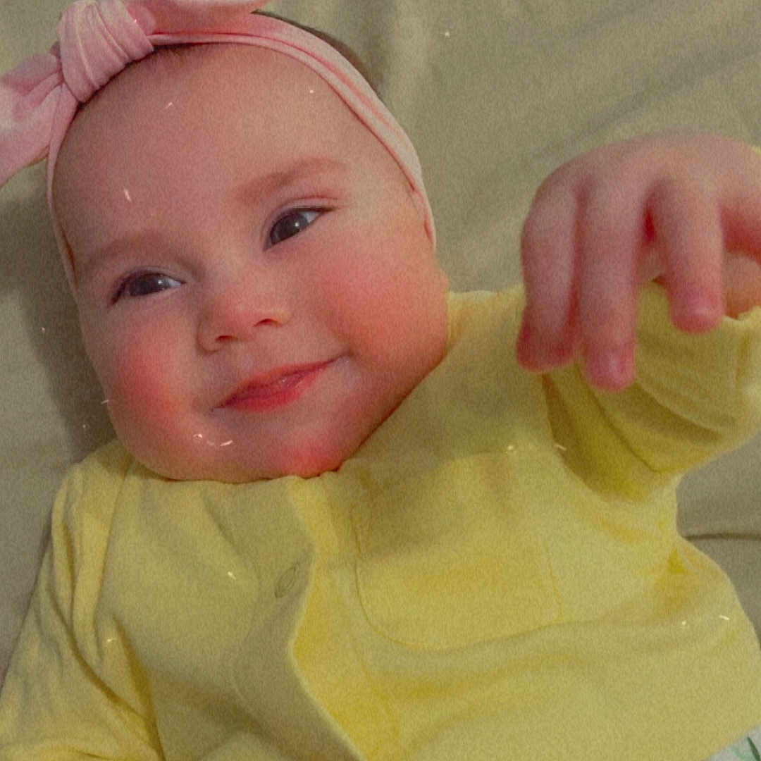 Jesira joined the competition — help win amazing prizes! baby, infant, smile, headband, yellow_cardigan, blanket, floral_pattern, cute, lying_down, happy, child, face, hand, soft_surface, indoors, portrait, apparel, person, toddler, young_child