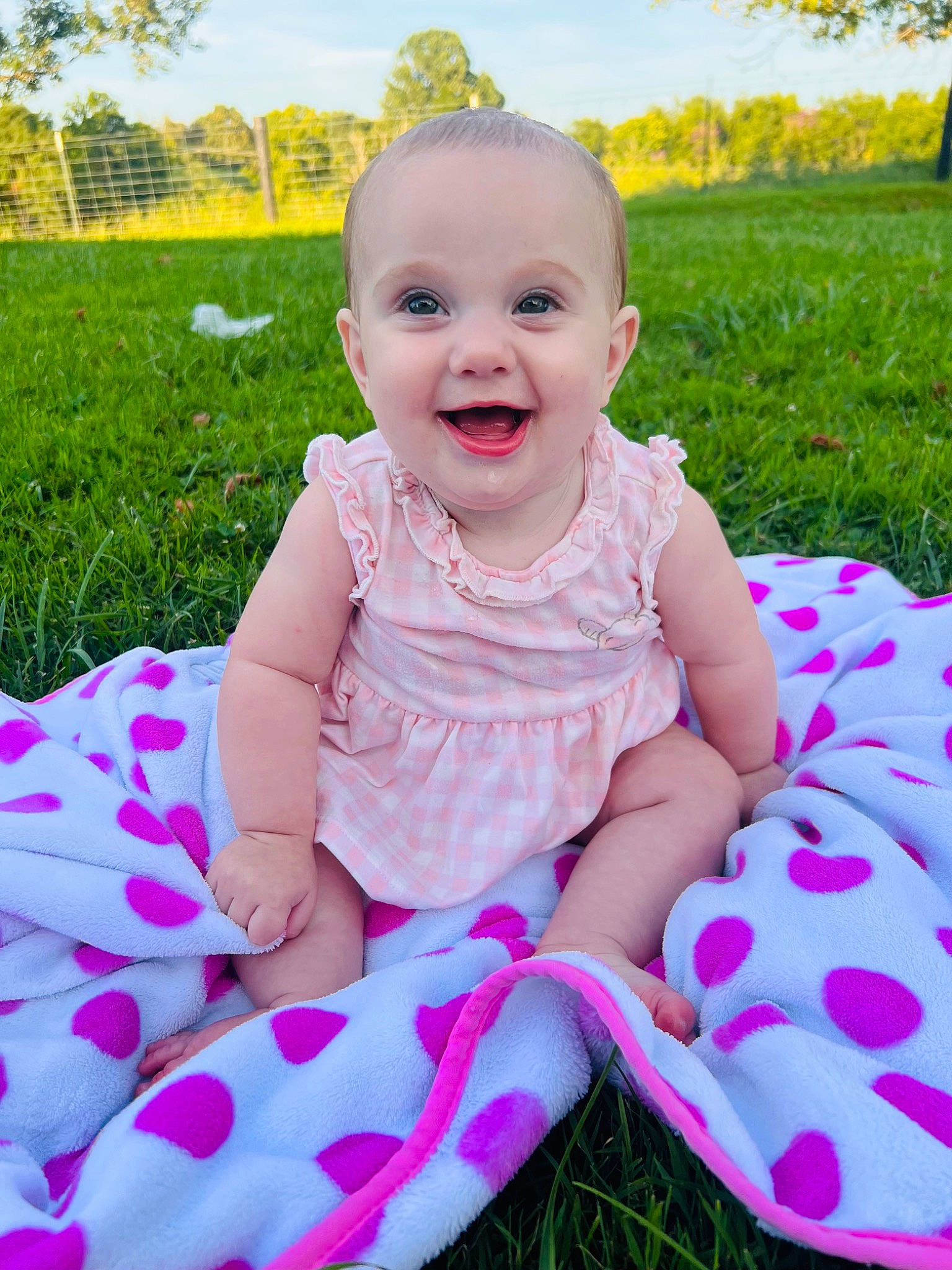 Madelyn is registered to the contest to win money with this photo: baby, baby_toddler_clothing, child, dress, fun, grass, happy, joy, leisure, magenta, meadow, pattern, people_in_nature, person, pink, plant, recreation, skin, sky, smile
