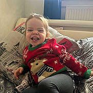 Ambre a rejoint le concours — aidez-le/la à gagner de superbes lots ! toddler, child, smiling, sweater, red, reindeer, christmas, bed, pillow, pattern, window, curtain, indoor, happy, person, clothing, face, leggings, home, cozy