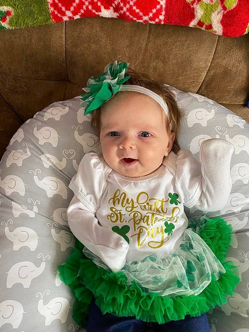 Sarah is registered to the contest to win money with this photo: baby, baby_products, baby_toddler_clothing, child, costume_hat, event, face, fashion_accessory, green, hair_accessory, happy, head, headgear, headpiece, pattern, person, ruffle, sleeve, smile, toddler