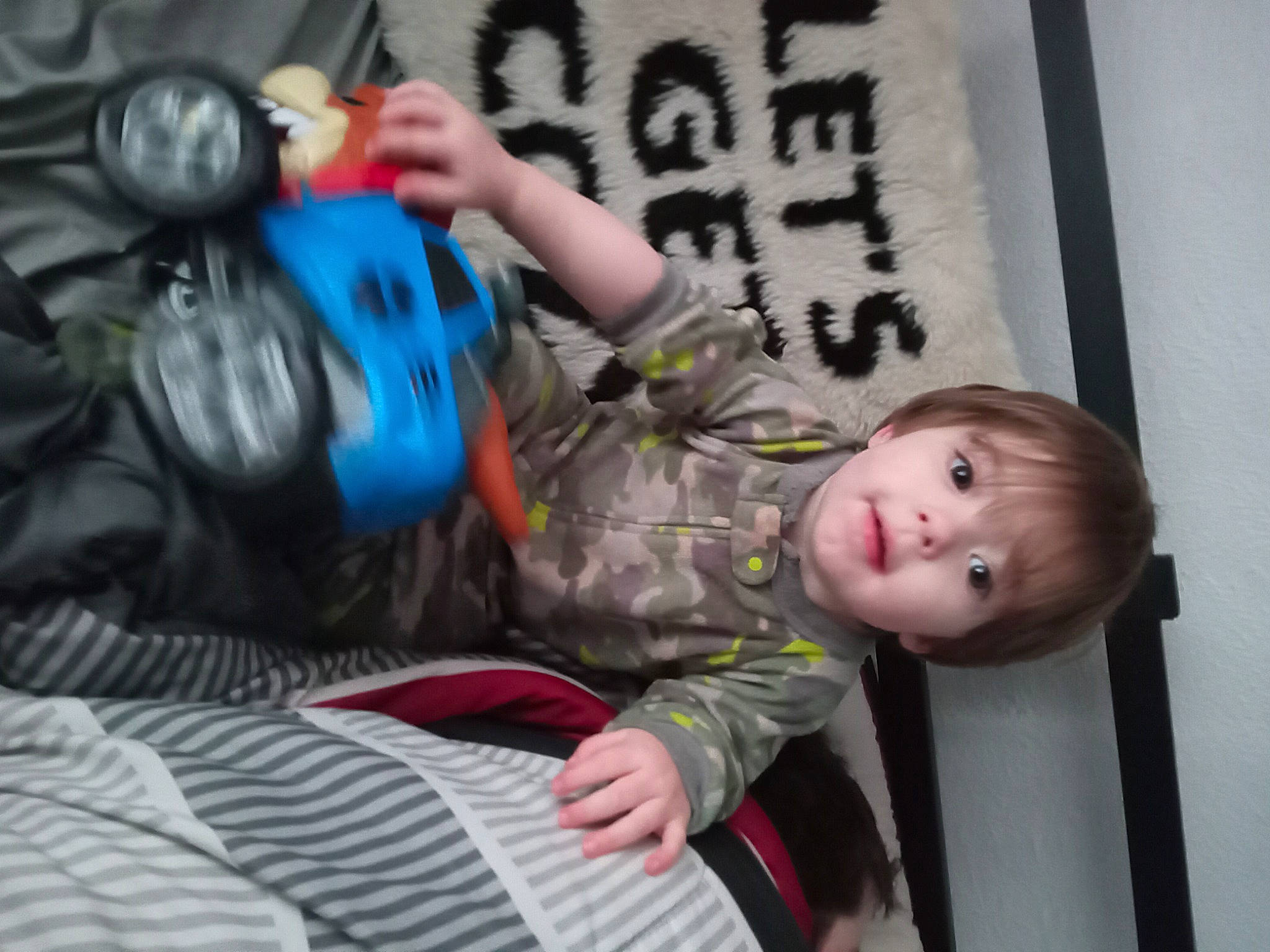 Zane Rayden is registered to the contest to win money with this photo: baby, baby_products, baby_toddler_clothing, bag, child, comfort, electric_blue, fun, linens, luggage_and_bags, person, personal_protective_equipment, play, room, sitting, sleeve, t_shirt, textile, toddler