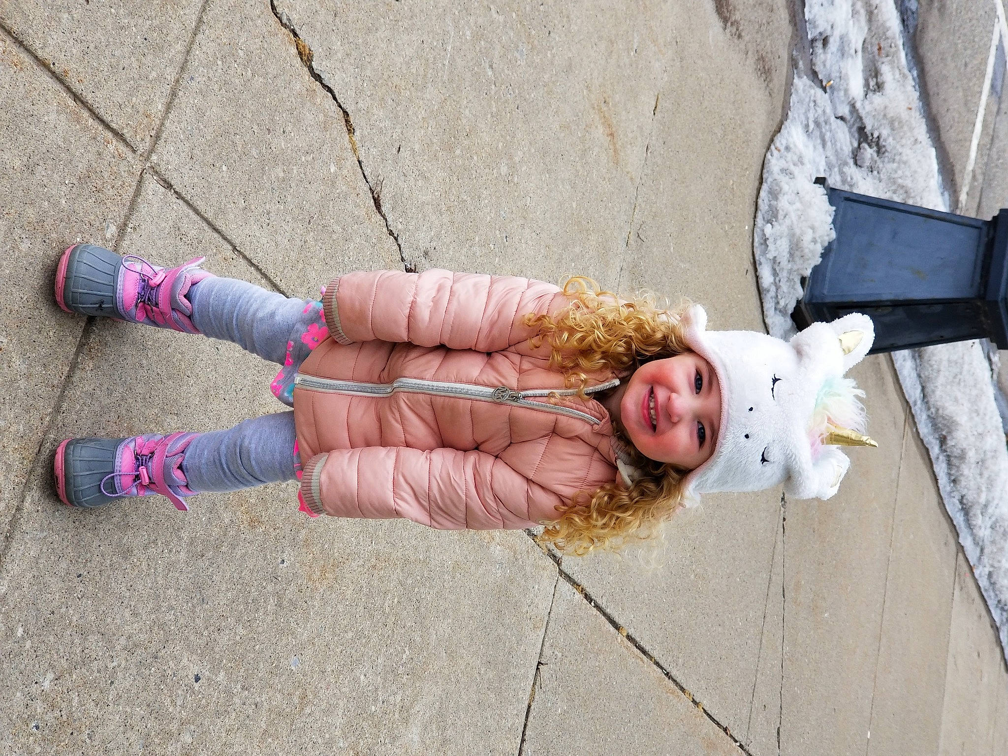 Brianne is registered to the contest to win money with this photo: asphalt, child, cobblestone, concrete, fashion_accessory, foot, fun, happy, headwear, human_leg, joy, knee, nail, pattern, pedestrian, person, road, road_surface, sidewalk, smile