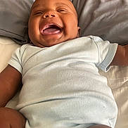 Xavier joined the competition — help win amazing prizes! baby, child, infant, laughing, onesie, smiling, happy, lying_down, bed, pillow, skin, face, mouth_open, joyful, cute, indoor, human, person, clothing, sleepwear