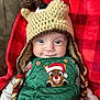 Leo is registered to the contest to win money with this photo: baby, child, face, hat, crochet, reindeer, green_overalls, christmas, holiday, smile, plaid_blanket, red, cute, infant, portrait, eyes, button, warm_clothing, festive, indoors