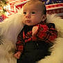 Leo is registered to the contest to win money with this photo: baby, infant, plaid_shirt, black_suspender, fluffy_blanket, christmas_lights, holiday_presents, festive, cozy, indoors, celebration, cute, portrait, child, warm, smiling, decorations, seasonal, holiday, background