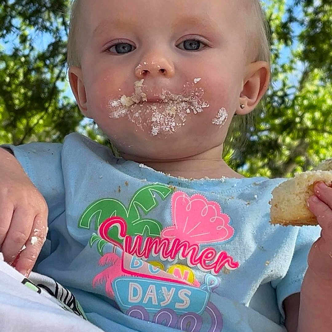 Brookelynn is registered to the contest to win money with this photo: baby, bread, clothing, cream, dessert, eating, face, flower, food, grass, head, icecream, icing, person, photography, plant, portrait, sitting, summer, t_shirt