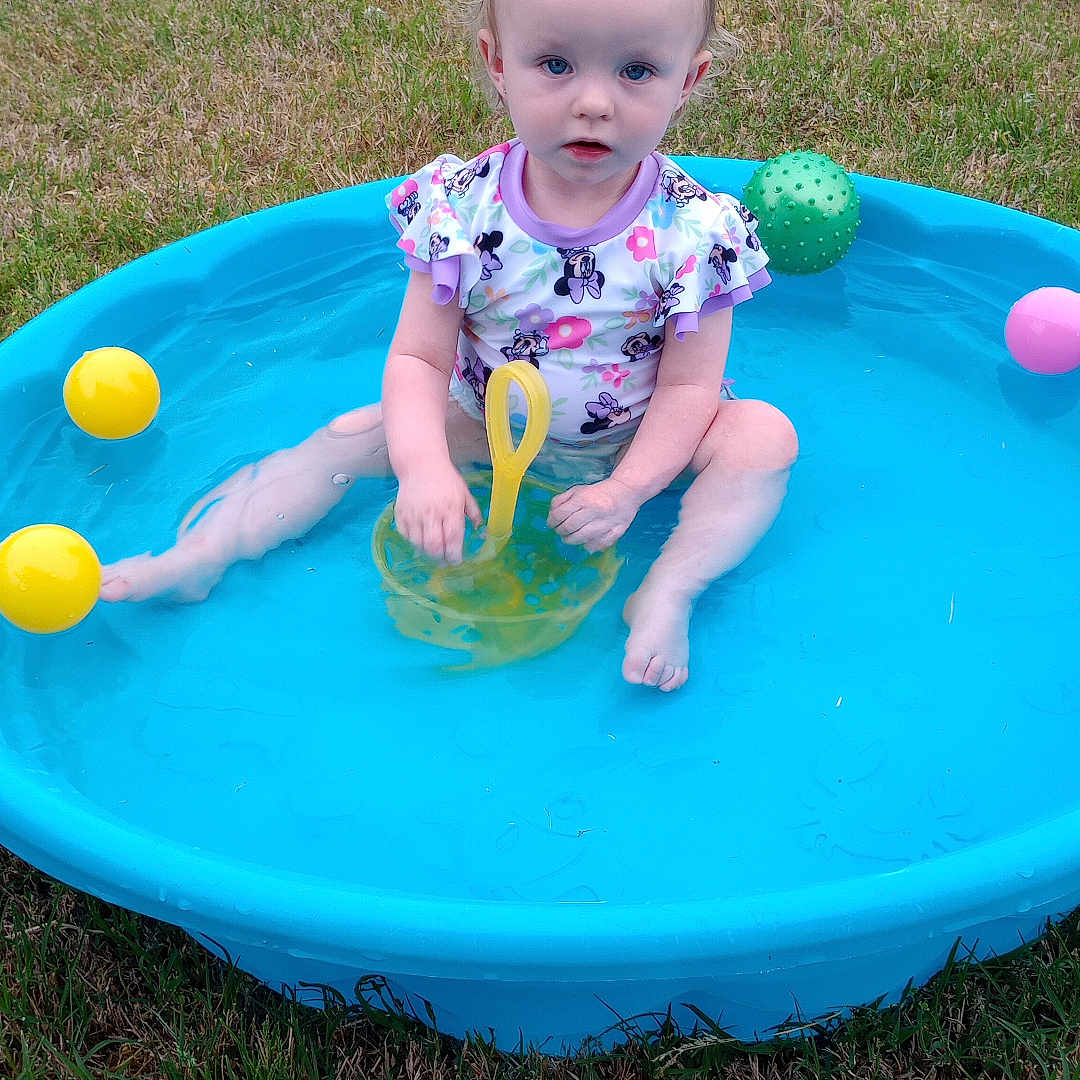 Brookelynn joined the competition — help win amazing prizes! ball, blue, child, cute, fence, fun, grass, green, outdoor, person, pink, play, pool, sitting, summer, toddler, toy, water, yellow, young