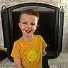 Noah Thompson joined the competition — help win amazing prizes! boy, brick_wall, bright, casual_clothing, child, cute, fireplace, happy, home, indoors, light, mitt, person, playful, portrait, short_hair, smiling, standing, yellow_tshirt, young