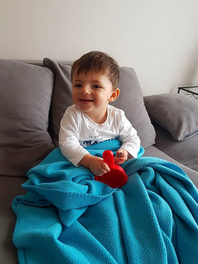 émiliano a rejoint le concours — aidez-le/la à gagner de superbes lots ! aqua, azure, baby, baby_toddler_clothing, comfort, couch, electric_blue, eye, furniture, human_leg, joy, lighting, linens, living_room, person, sitting, skin, sleeve, smile, t_shirt