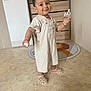 bottle, child, clothing, cute, dresser, face, floor, happy, home, indoor, lion_rug, marble_floor, person, rug, sandals, shoes, smiling, standing, toddler, toy