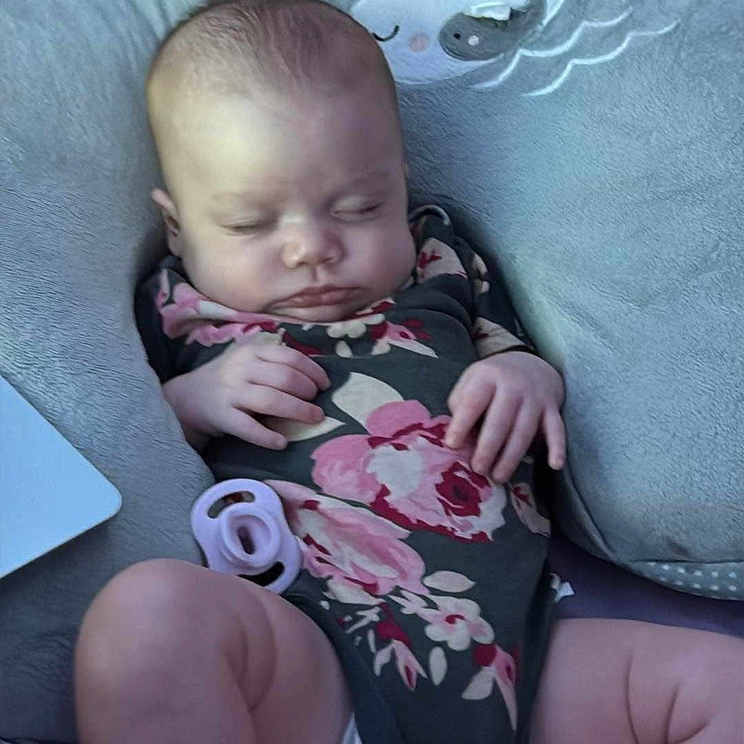 Layla is registered to the contest to win money with this photo: baby, bed, clothing, couch, cushion, face, furniture, head, homedecor, hosiery, indoors, newborn, person, photography, pillow, portrait, shorts, sitting, sleeping, sock