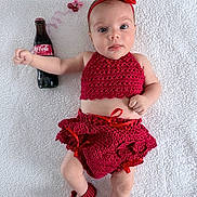 Luna is registered to the contest to win money with this photo: baby, infant, red_clothing, crochet, headband, shoes, coca_cola_bottle, straw, blanket, lying_down, cute, portrait, child, drink, accessory, white_background, expression, small_hands, small_feet, indoors