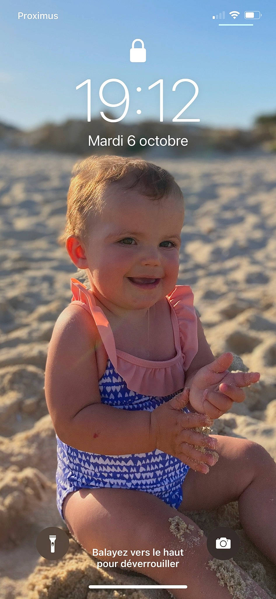 Chiara a rejoint le concours — aidez-le/la à gagner de superbes lots ! azure, baby_toddler_clothing, beach, body_of_water, clothing, facial_expression, finger, happy, head, human, joy, light, natural_environment, people_in_nature, people_on_beach, person, photograph, skin, smile, standing