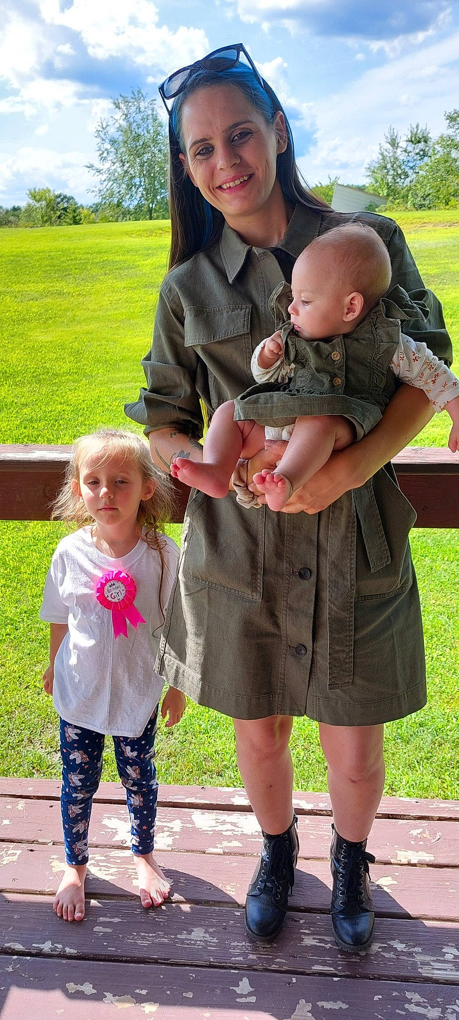 Kelly Rose is registered to the contest to win money with this photo: botany, clothing, face, fun, gesture, grass, green, hand, happy, interaction, joy, people_in_nature, person, photograph, pink, plant, shoe, skin, smile, standing