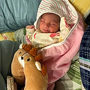Hinza Ammar Azizi is registered to the contest to win money with this photo: newborn, baby, sleeping, blanket, plush_toy, reindeer_slippers, pillow, bed, cozy, wrapped, infant, cute, soft, resting, child, indoors, comfort, peaceful, warm, toddler