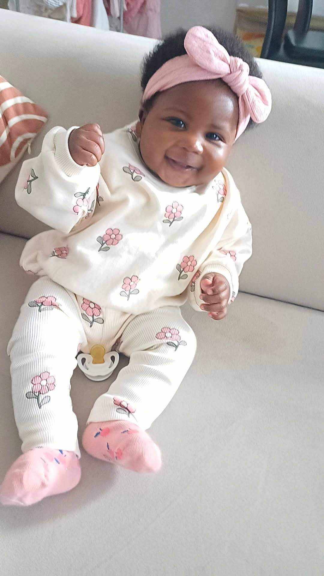 Melissa participe au concours pour gagner de l'argent avec cette photo : baby, infant, smiling, headband, pink, floral, outfit, socks, couch, indoor, person, cute, happy, child, seated, clothing, fabric, home, furniture, portrait