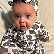 Nalani joined the competition — help win amazing prizes! baby, child, infant, face, headband, onesie, patterned_clothing, sitting, cute, portrait, indoor, soft_lighting, smiling, young_child, happy, person, curious, baby_girl, comfort, clothing