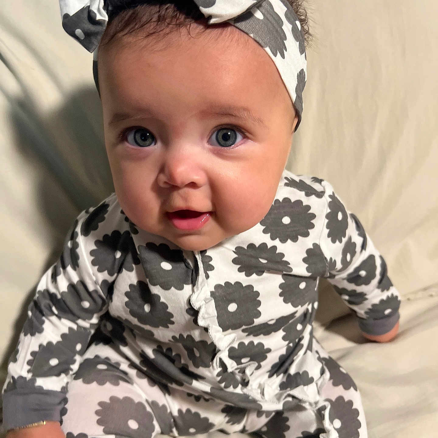 Nalani joined the competition — help win amazing prizes! baby, baby_girl, child, clothing, comfort, curious, cute, face, happy, headband, indoor, infant, onesie, patterned_clothing, person, portrait, sitting, smiling, soft_lighting, young_child