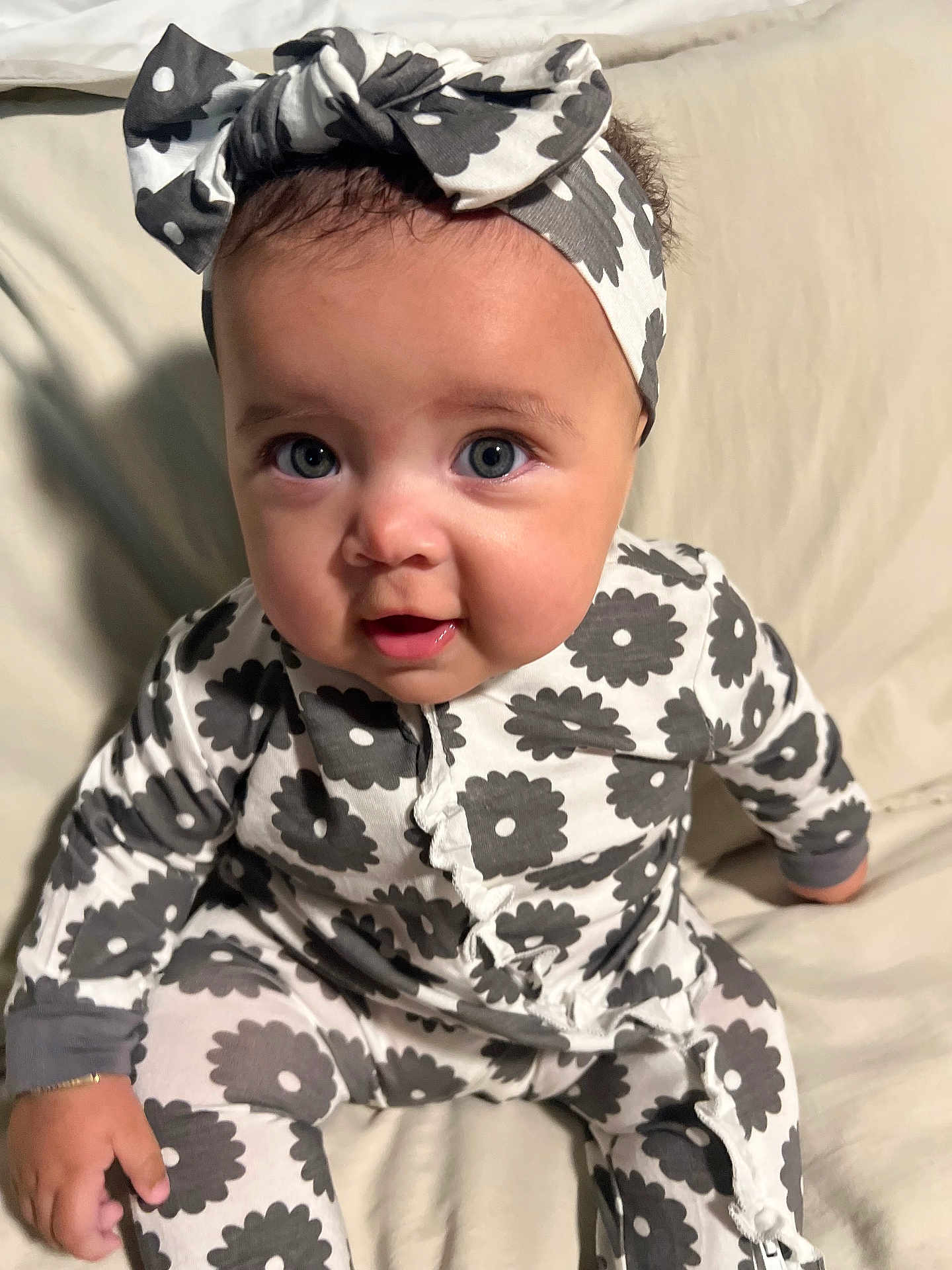 Nalani joined the competition — help win amazing prizes! baby, child, infant, face, headband, onesie, patterned_clothing, sitting, cute, portrait, indoor, soft_lighting, smiling, young_child, happy, person, curious, baby_girl, comfort, clothing